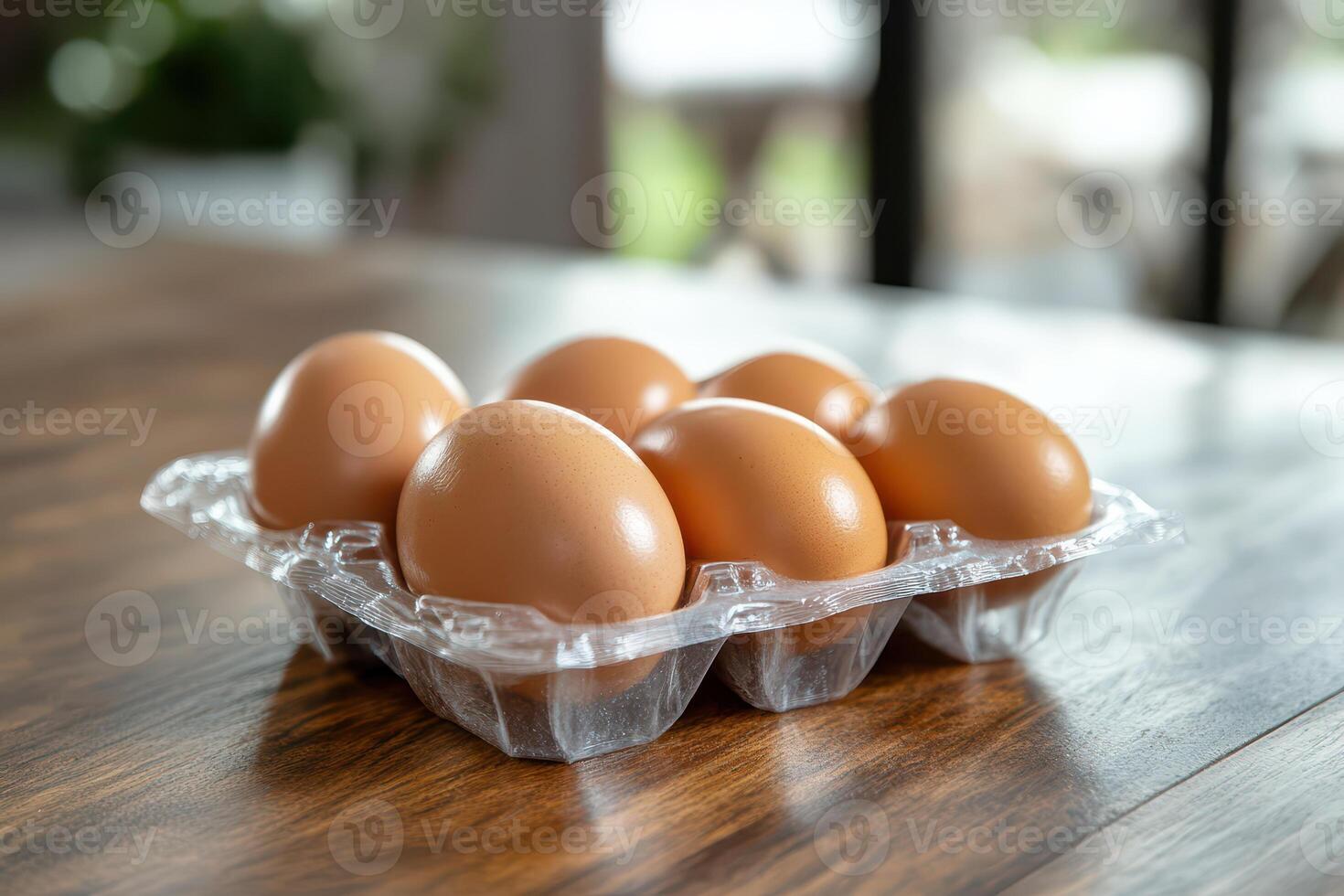 Six eggs in a plastic container on a wooden table photo