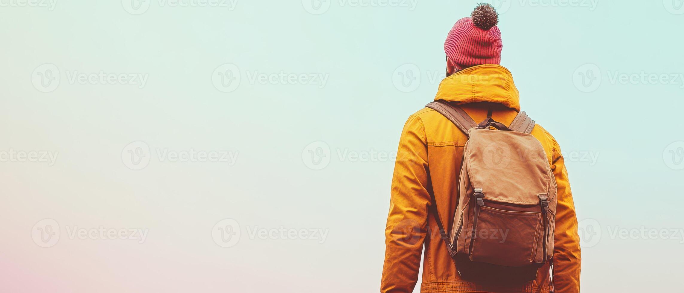 A person with a backpack standing in front of a colorful background photo