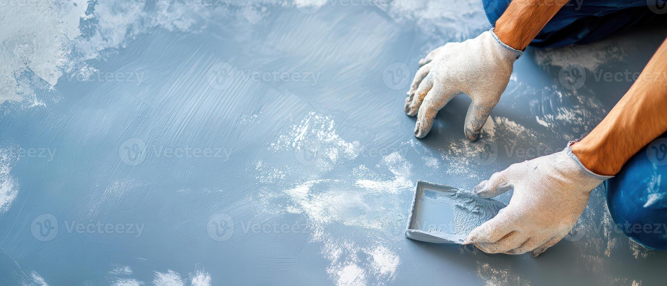 A person in blue gloves is painting a wall photo