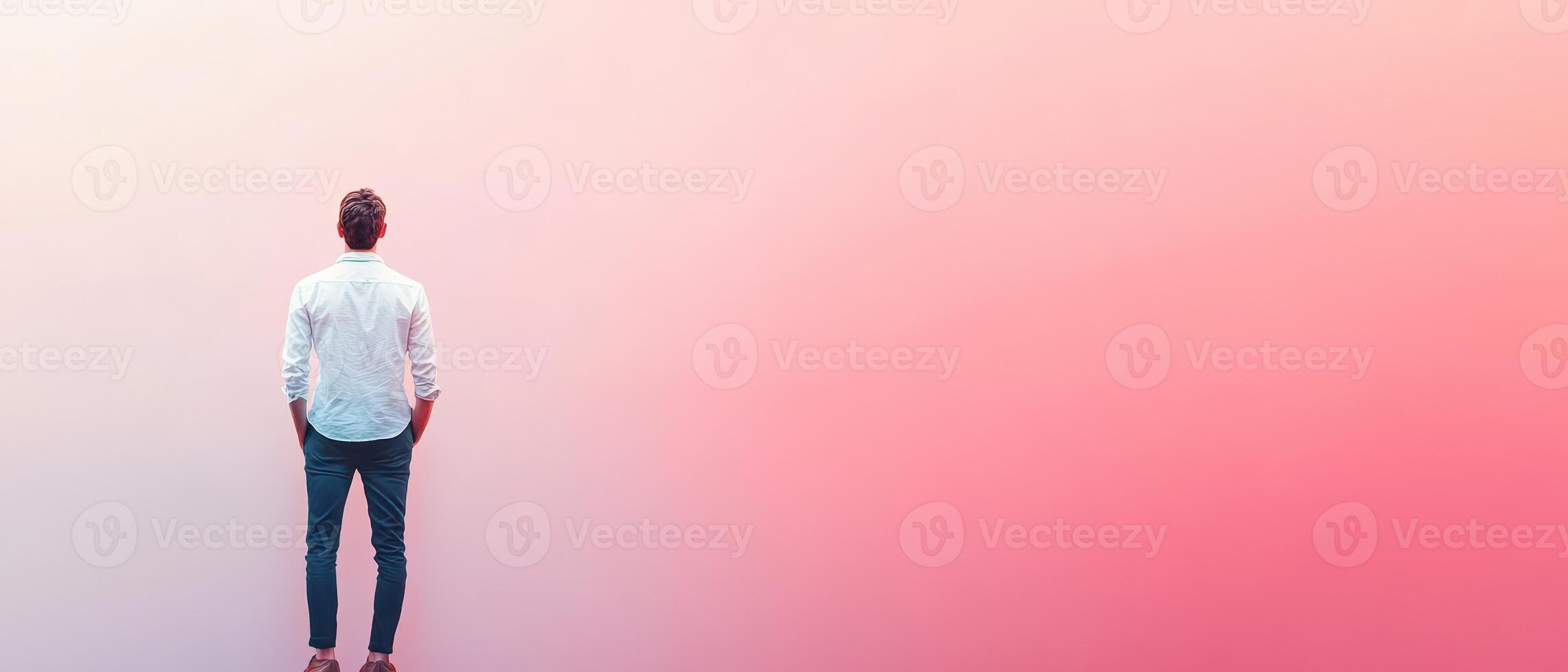 A man standing in front of a pink and red background photo