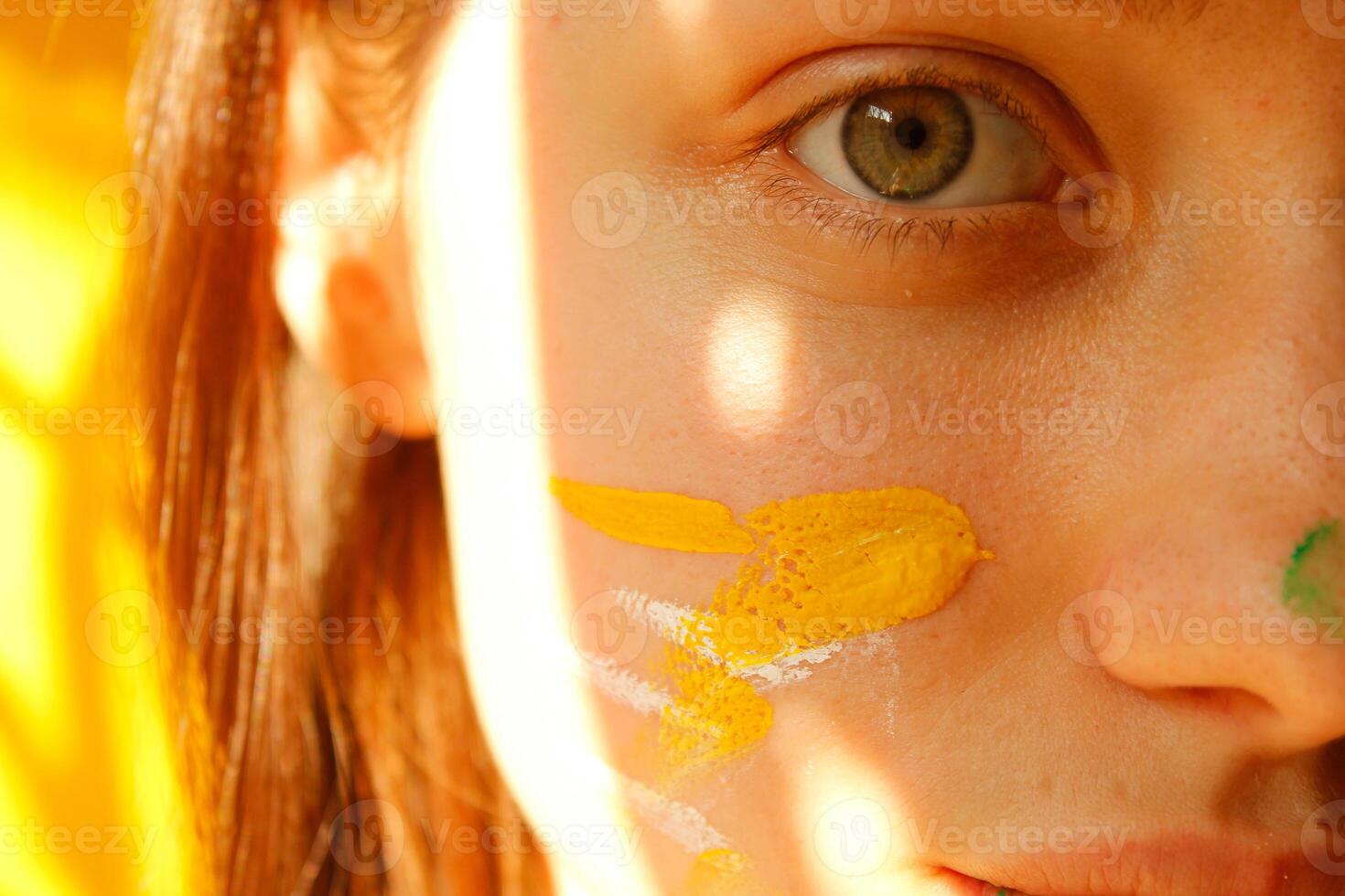Close up of a young woman with paint on her face and mouth photo