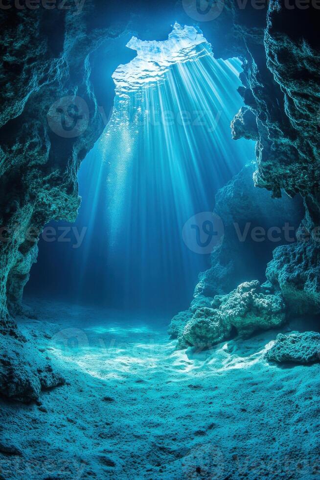 Underwater Cave View. Light streams through the open ceiling. Blue sea water. Sandy ocean floor with rocks. Natural aquatic scene. photo