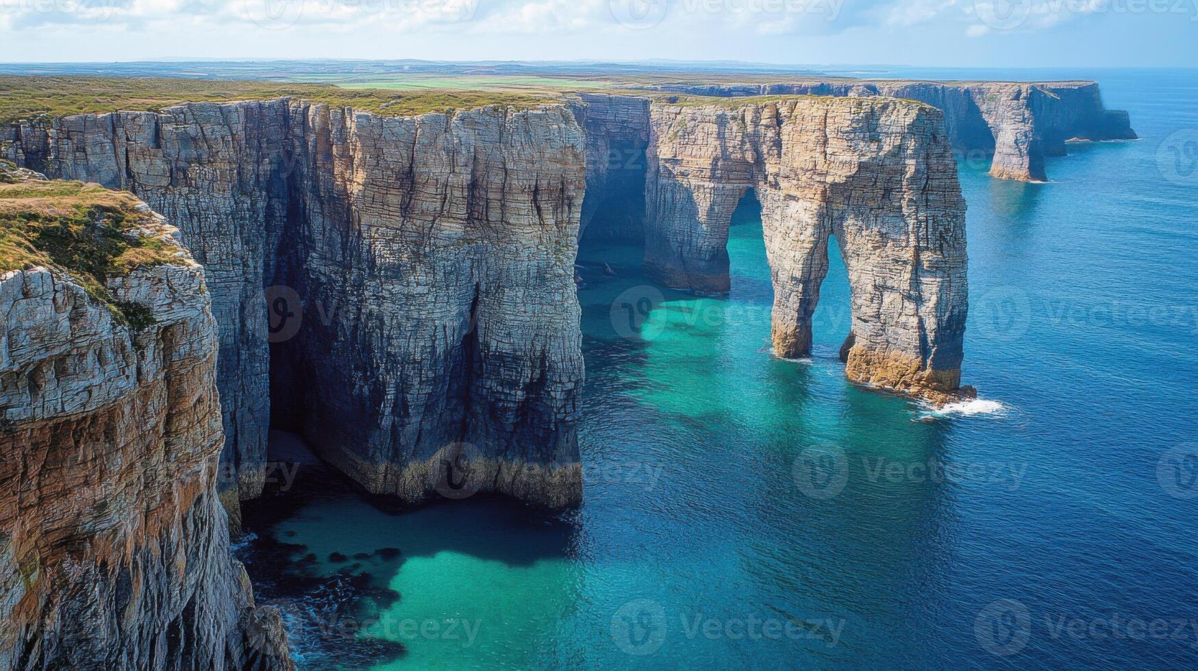 Coastal Cliffs. Rocky cliffs in blue water. Scenic ocean landscape. Arches made of stone. Aerial view of natural formations on a sea coast. photo