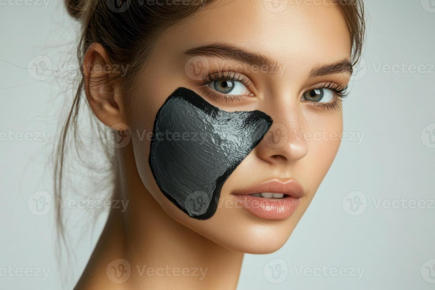 Woman with black mask on face. Natural skin care treatment. Beauty concept. Isolated against a neutral background. Close up on facial treatment. photo