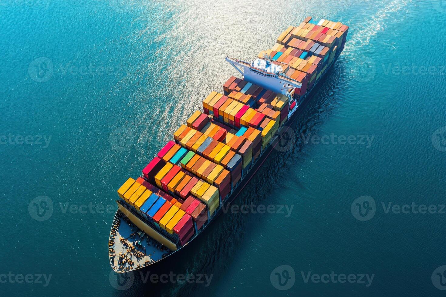 Large cargo ship transporting colorful containers sails on blue ocean. Aerial view of freight vessel in open sea during daytime. Global shipping concept. photo