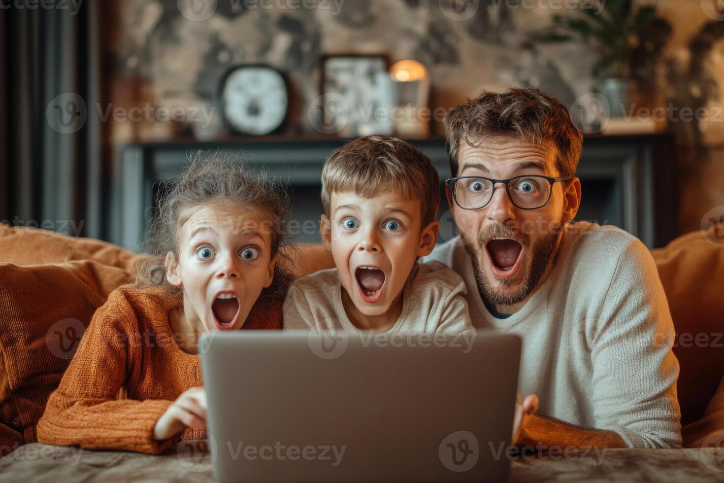 Father and two children look at a laptop computer with surprised expressions. They sit together on a sofa in a cozy home interior. photo
