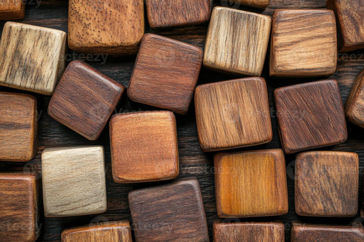 Many wooden blocks. Square shapes with wood texture. Brown color tones on a dark wood surface. Close up shot of textured cubes. photo