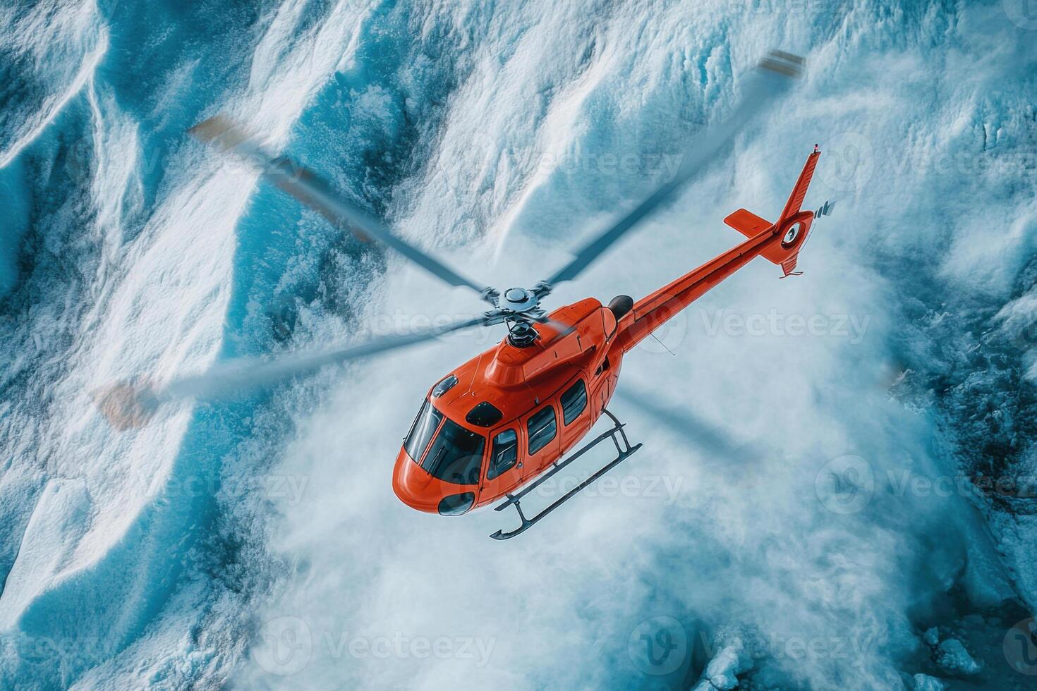 Red helicopter flying above ice field. Blades spinning above a snowy landscape. Aerial view of a mountainous glacier covered with snow and ice. photo