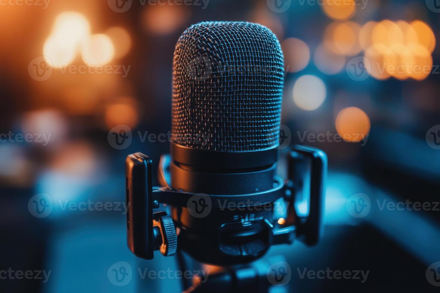Studio microphone on stand. Dark metal microphone. Sound recording equipment. Close up view of microphone. Lights in soft focus background. Blue and orange colors. photo
