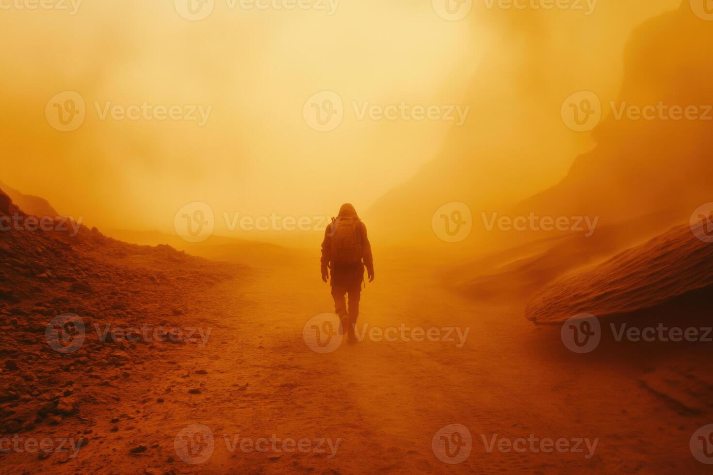 Person wearing protective suit walking on a dry planet surface during dust storm with orange sunlight. Rocky and hazy landscape background. photo