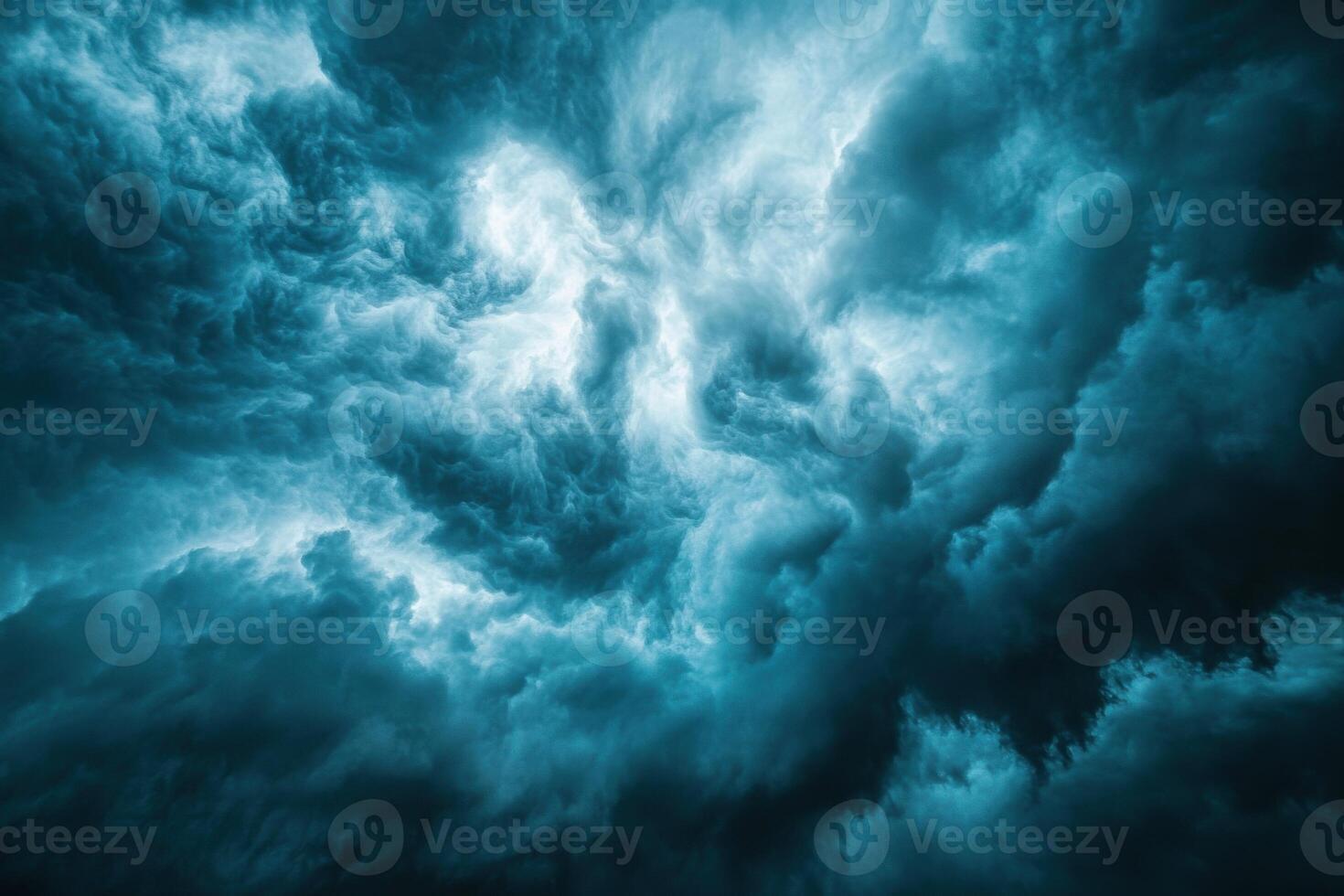 Dramatic sky filled with dark teal storm clouds. Bright light shines through the swirling and textured cloudscape. Impressive weather background. photo