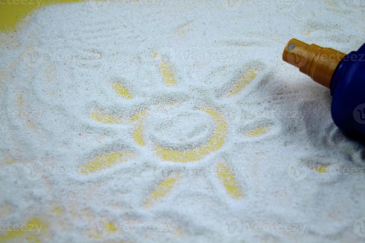 The sun is drawn on a sandy background, a bottle of protective oil is visible in the background. The concept of tourism, vacation, summer. photo