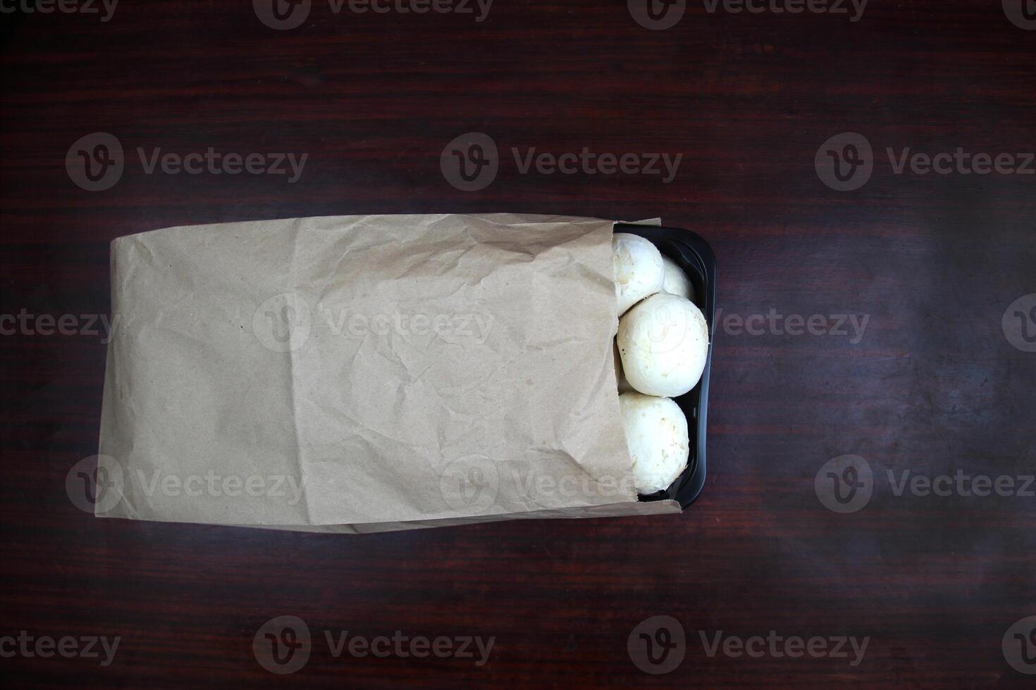 Mushrooms lie in a craft bag on a dark background photo