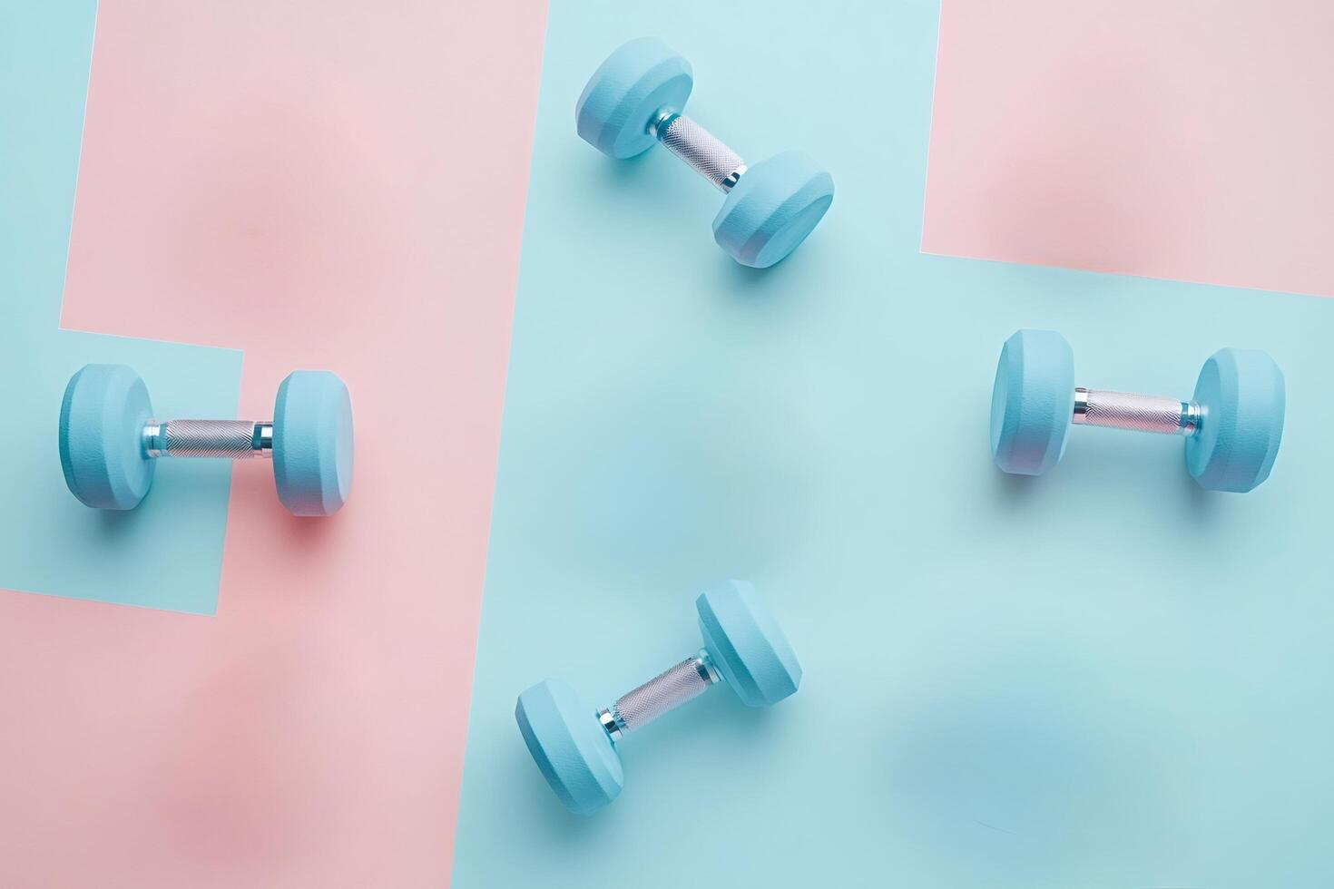 Light blue dumbbells on pink and light blue background representing fitness photo