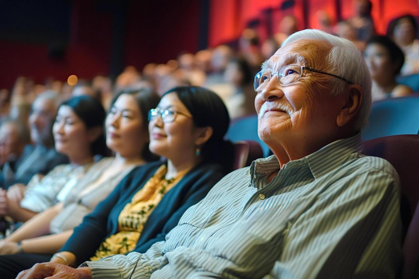 Elderly asian man enjoying movie in theater with audience watching film photo