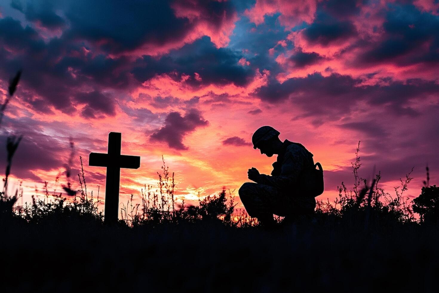 Soldier praying at sunset near cross silhouette photo