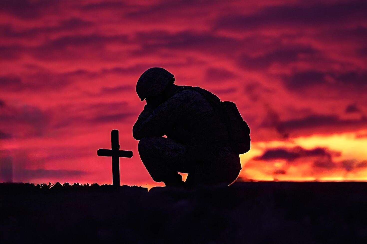 Soldier praying at grave during sunset remembering fallen comrades photo