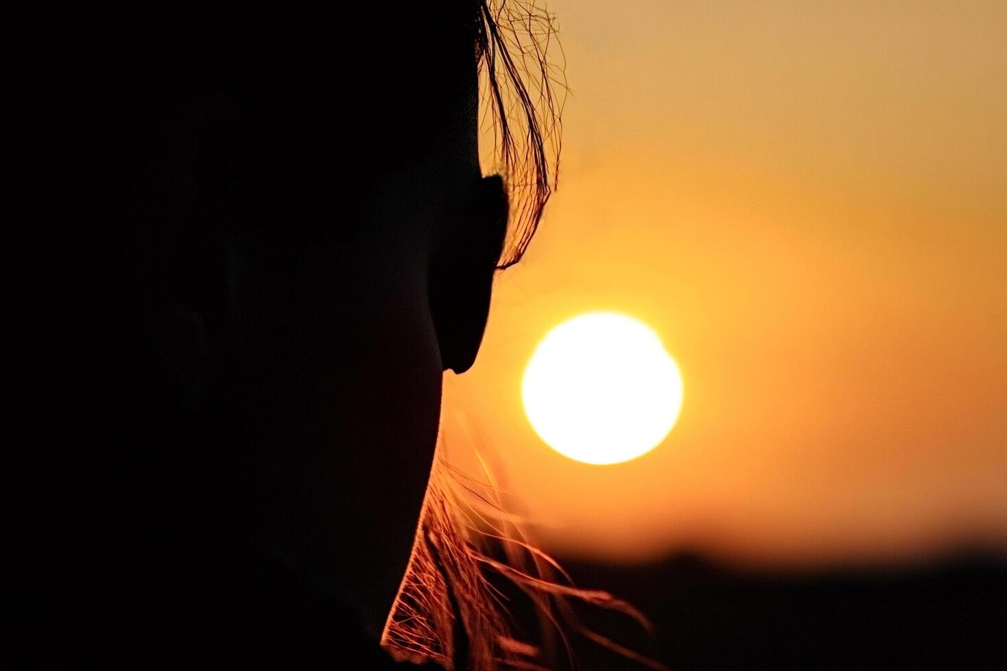 Woman watching golden sunset silhouette of peaceful contemplation photo