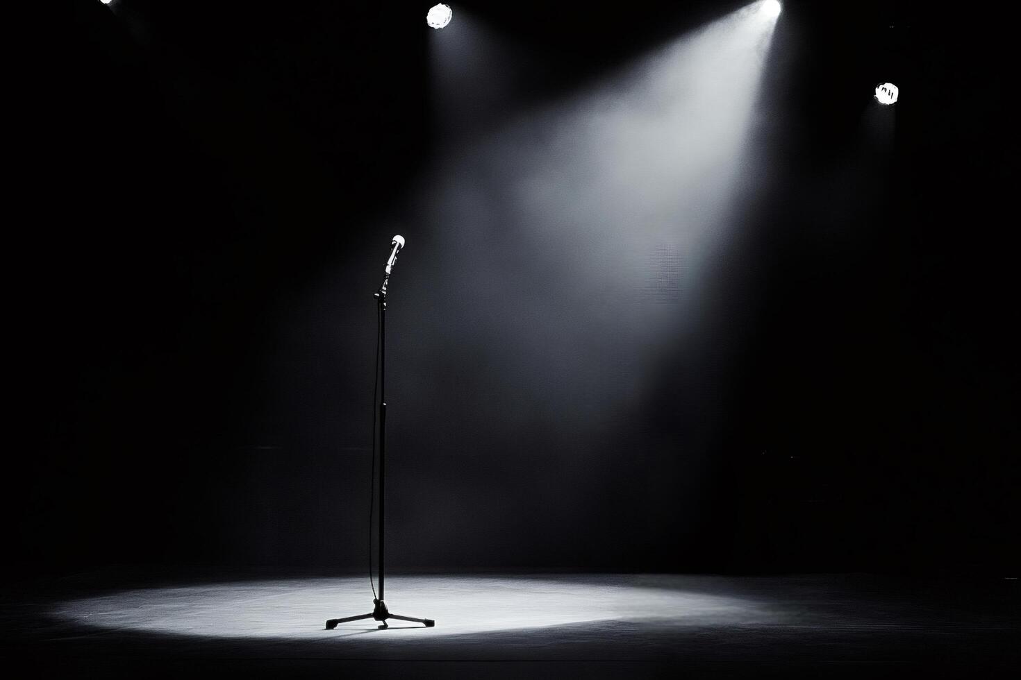 Microphone stands on empty stage awaiting performer under spotlights photo