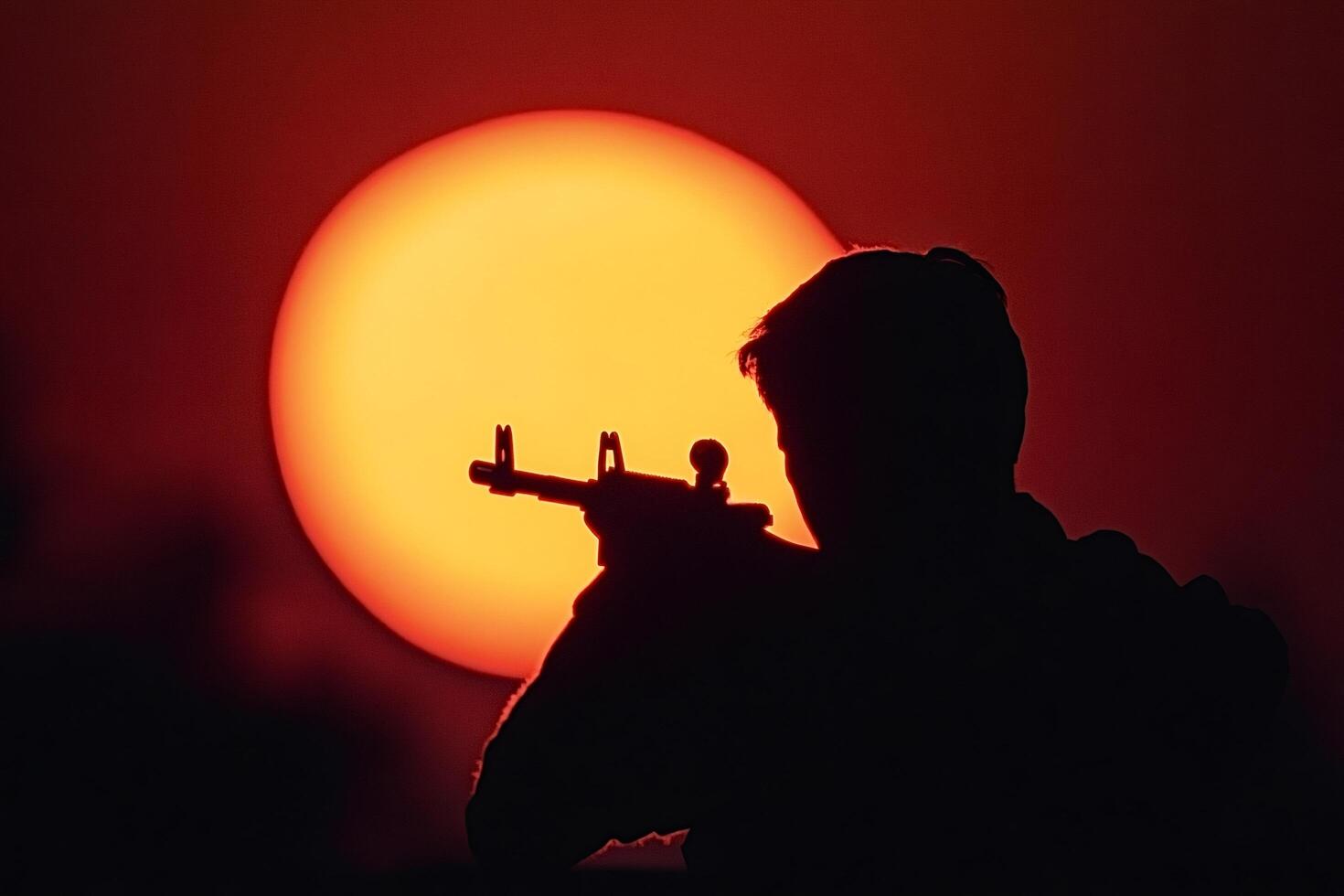 Soldier aiming with assault rifle at sunset silhouette photo