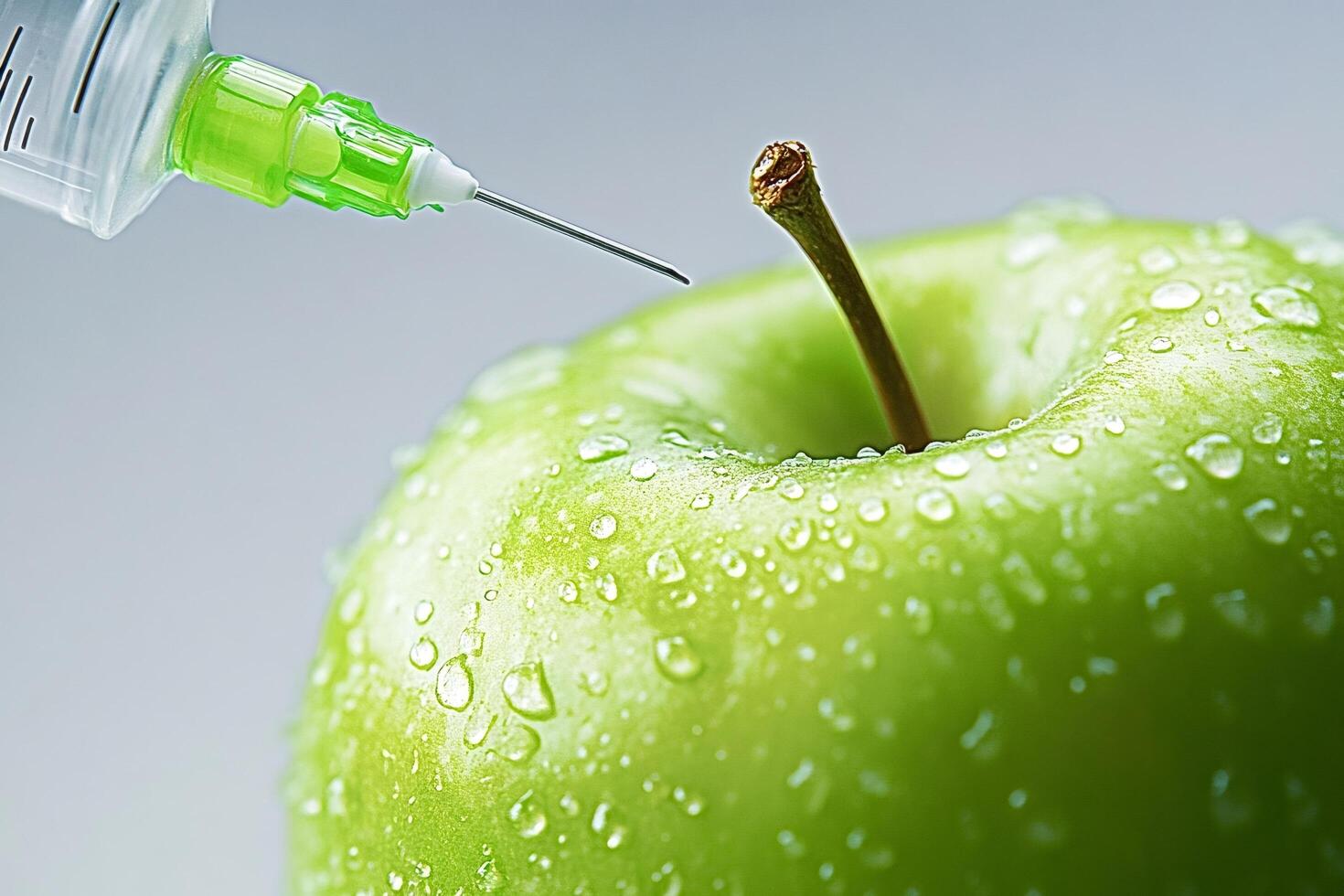 Syringe injecting green liquid into fresh green apple genetically modified food photo