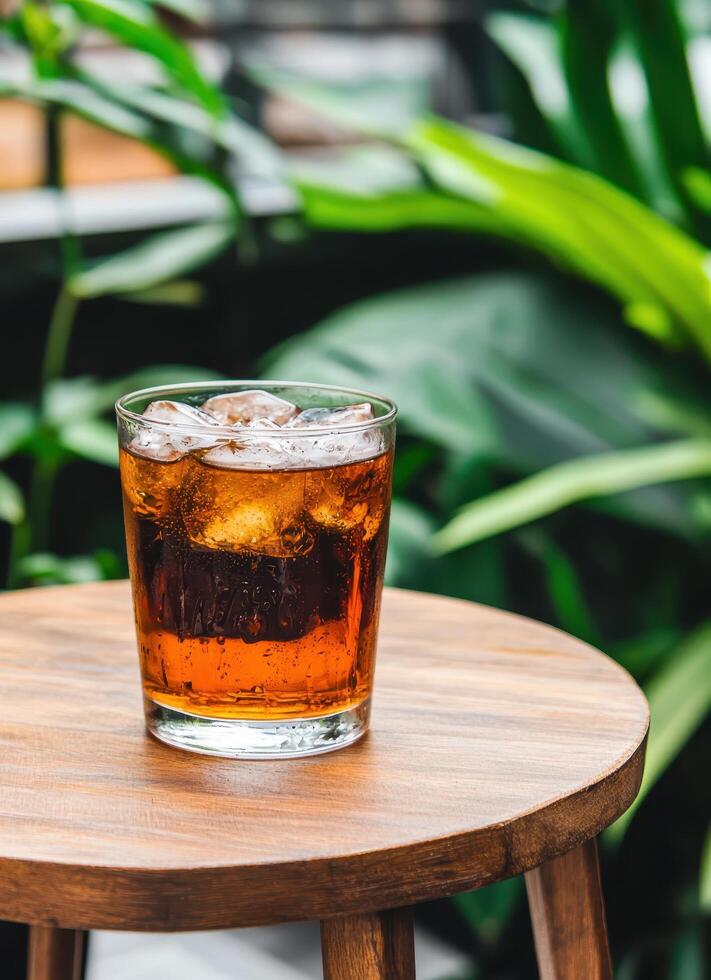 Refreshing Cola Drink on Wooden Table Outdoor Setting Nature Background Copyspace for Use photo