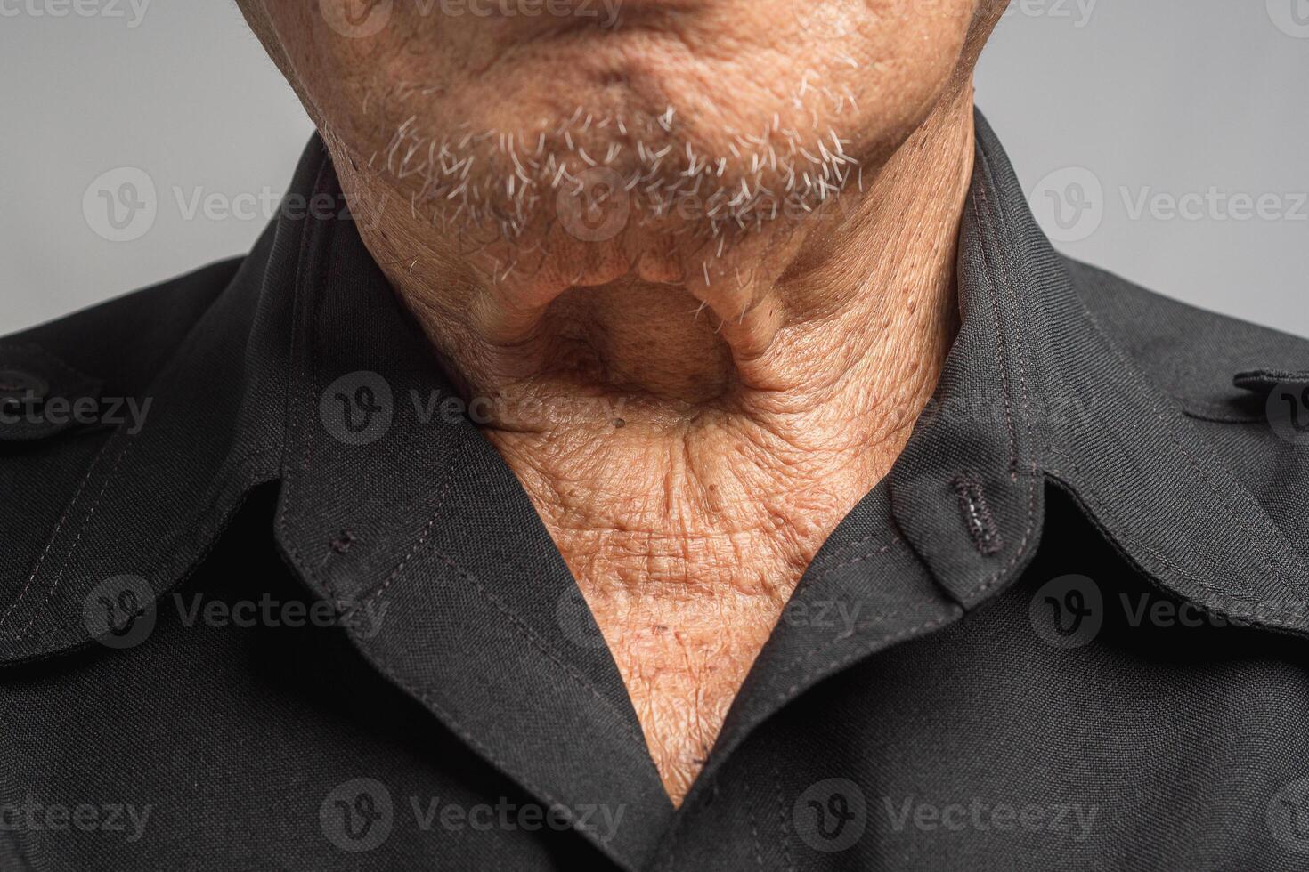 Close-up of wrinkled neck a senior man while standing on a gray background photo