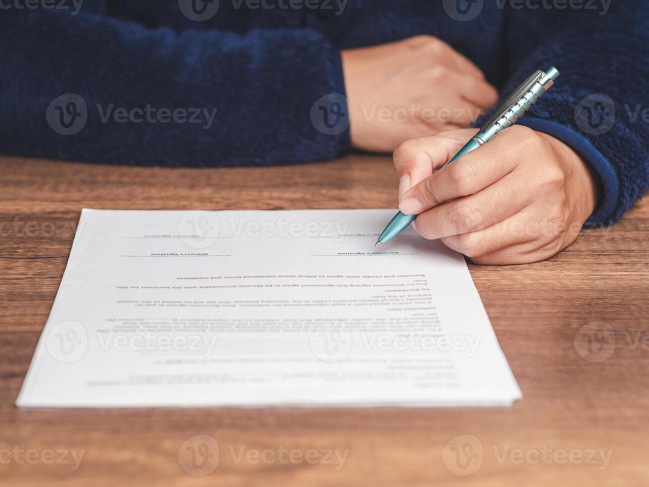 Close-up of signing a lease contract or agreement while sitting at the table photo