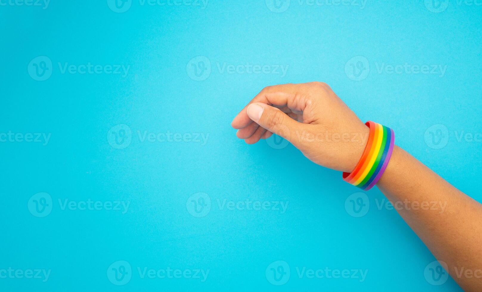 Top view of rainbow wristband in the wrist on a blue background. Close-up. photo