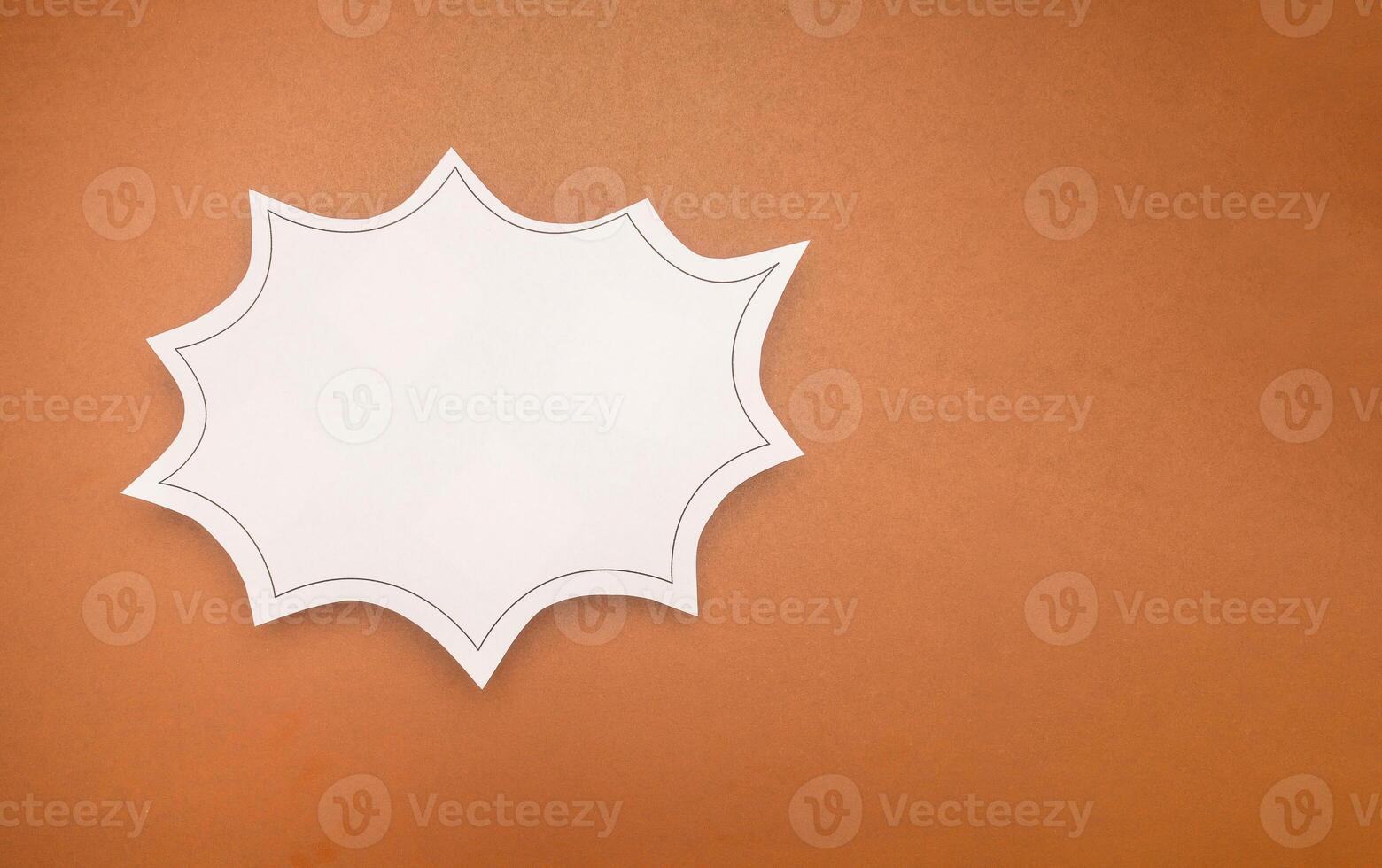 Top view of a blank white comic speech bubble on a brown background. photo