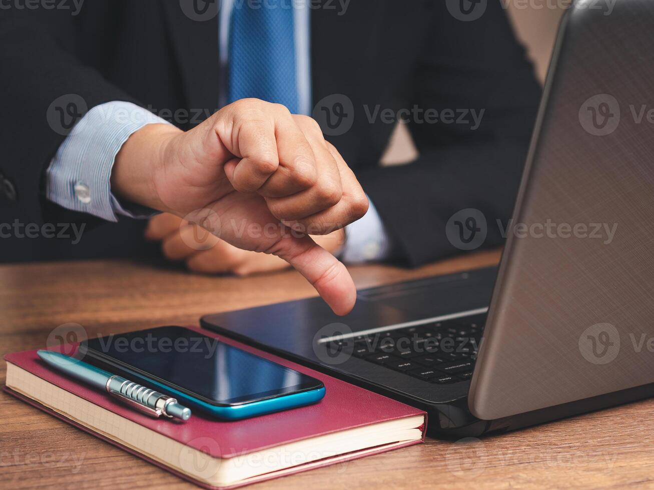 Close-up of a businessman showing a thumbs down for dislike service while sitting at the table. photo