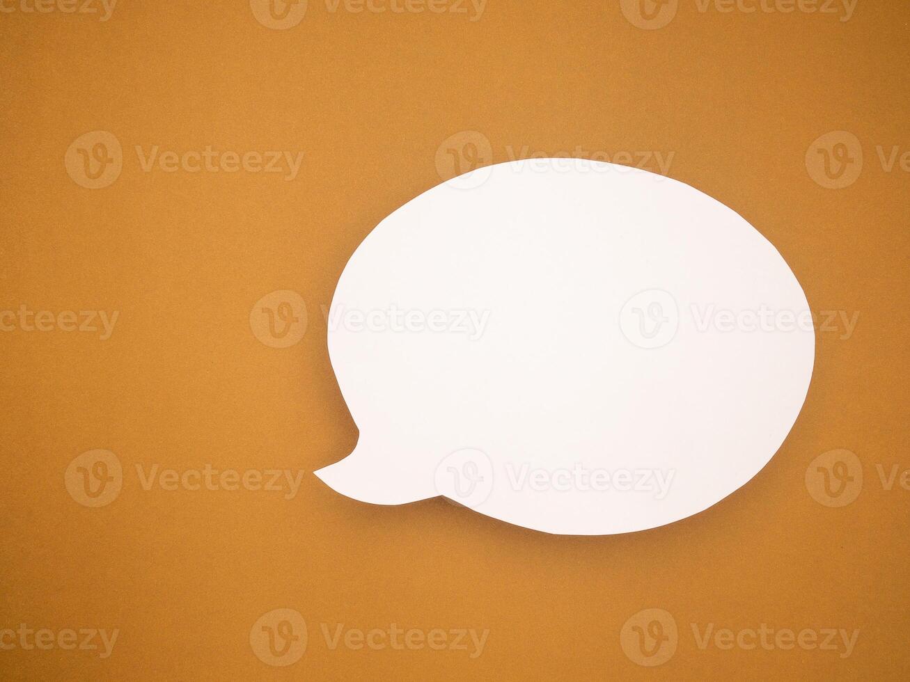 A blank white speech bubble on a brown background photo