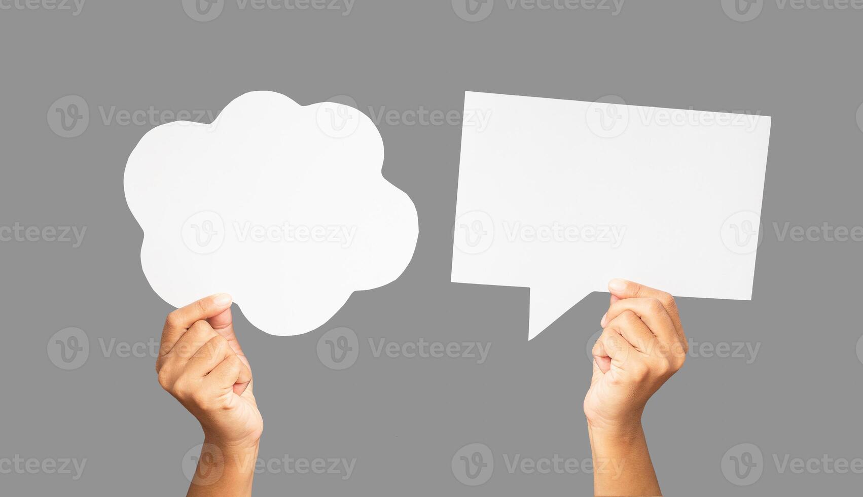 Close-up of hands holding a white speech bubbles against a gray background photo