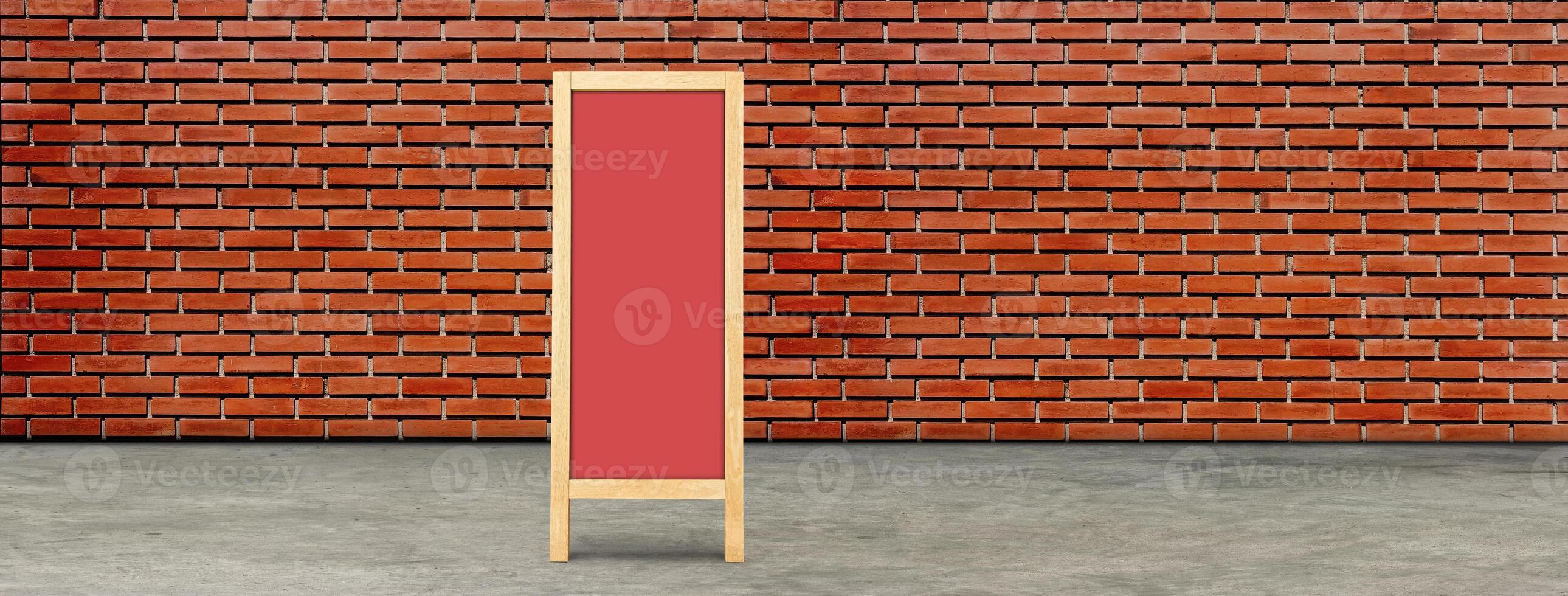 Vintage red wooden chalkboard with space for text, red brick wall background. photo