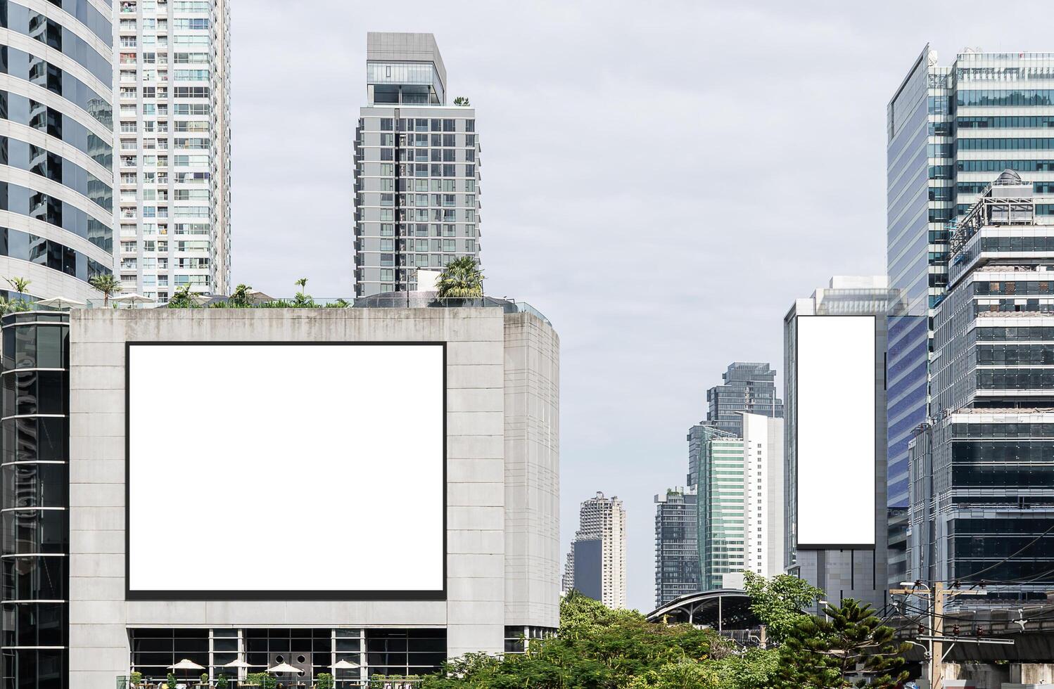 Two white mock up horizontal and vertical large LED display billboard on tower building. Clipping path for mockup photo