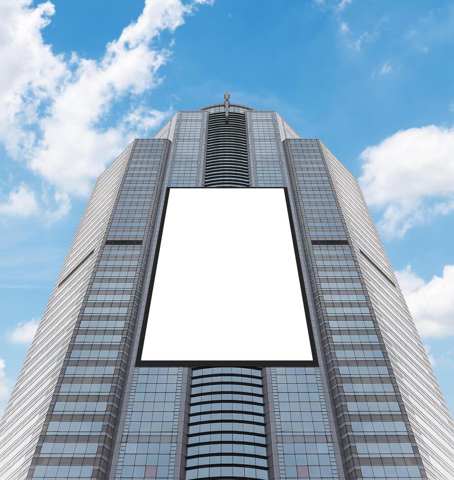 Bottom up view tower building with white mock up vertical LED display billboard. Clipping path for mock up photo