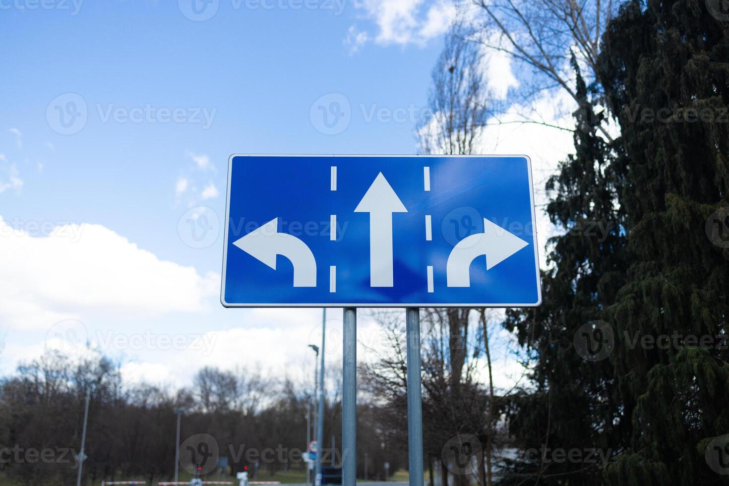 Road Sign with Left, Right, and Straight Arrow Directions on Blue Background photo