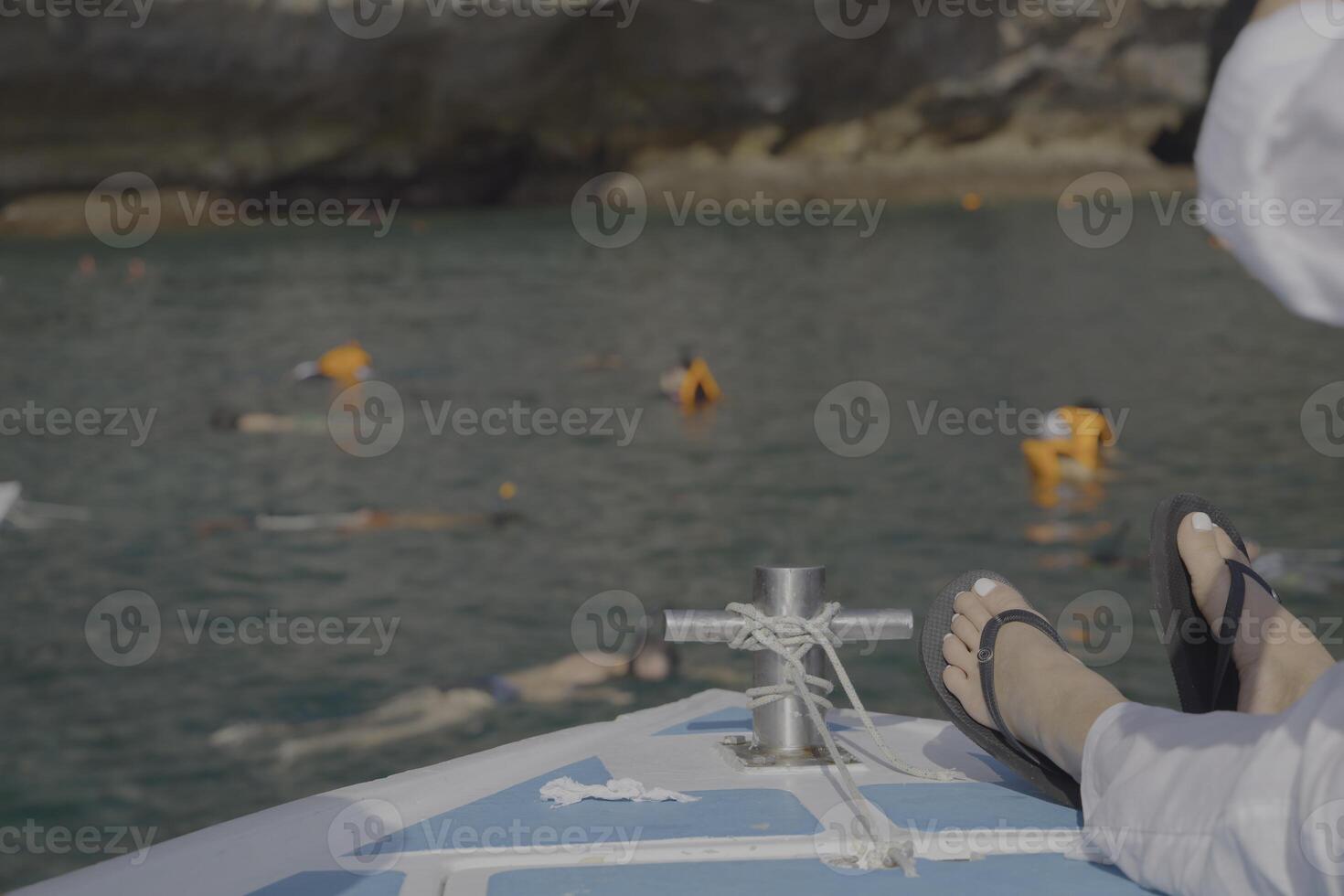 Enjoy a soothing and relaxing boat trip with swimmers in the clear, inviting waters photo