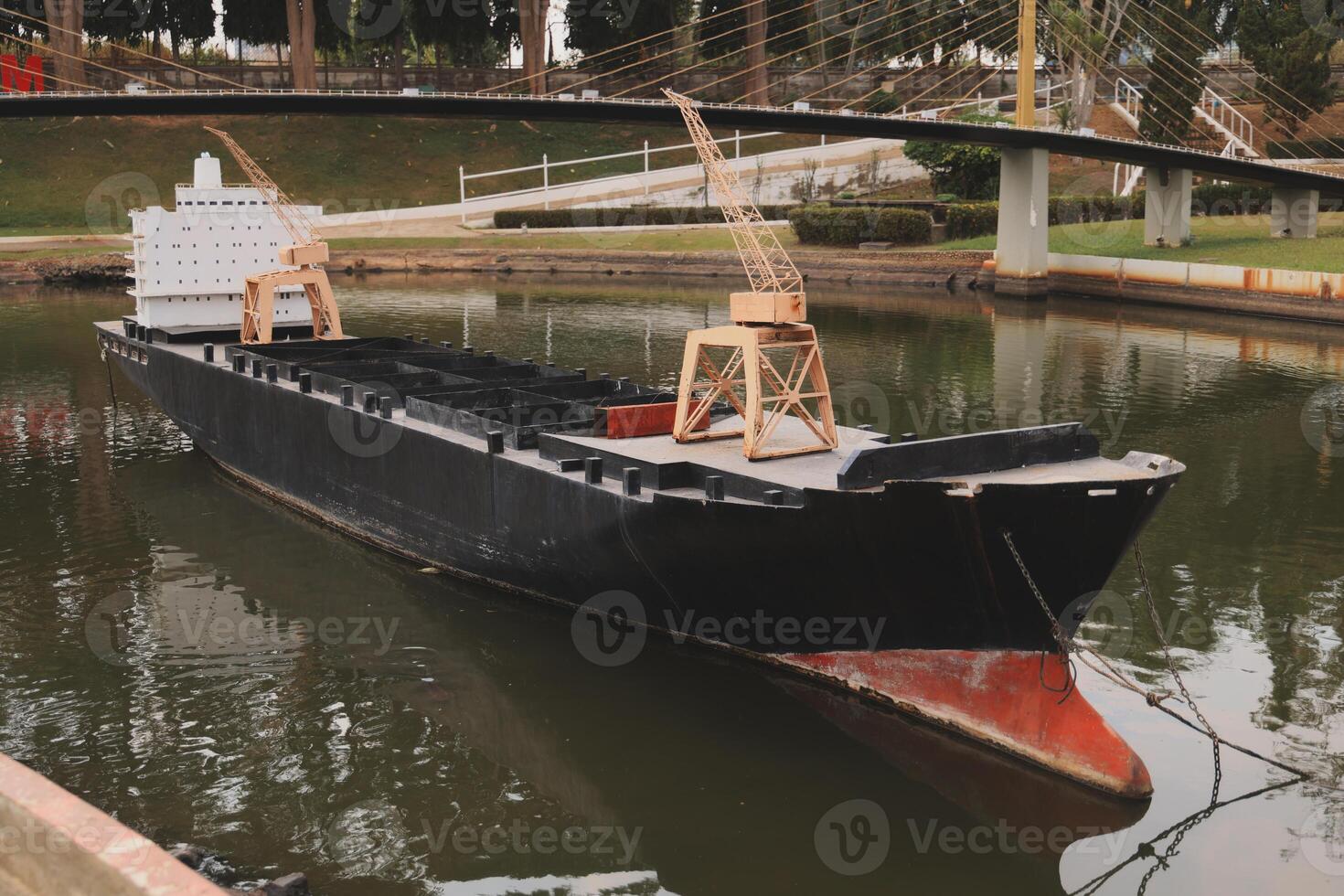 A unique cargo ship gracefully navigates the tranquil waters of a bustling harbor area photo
