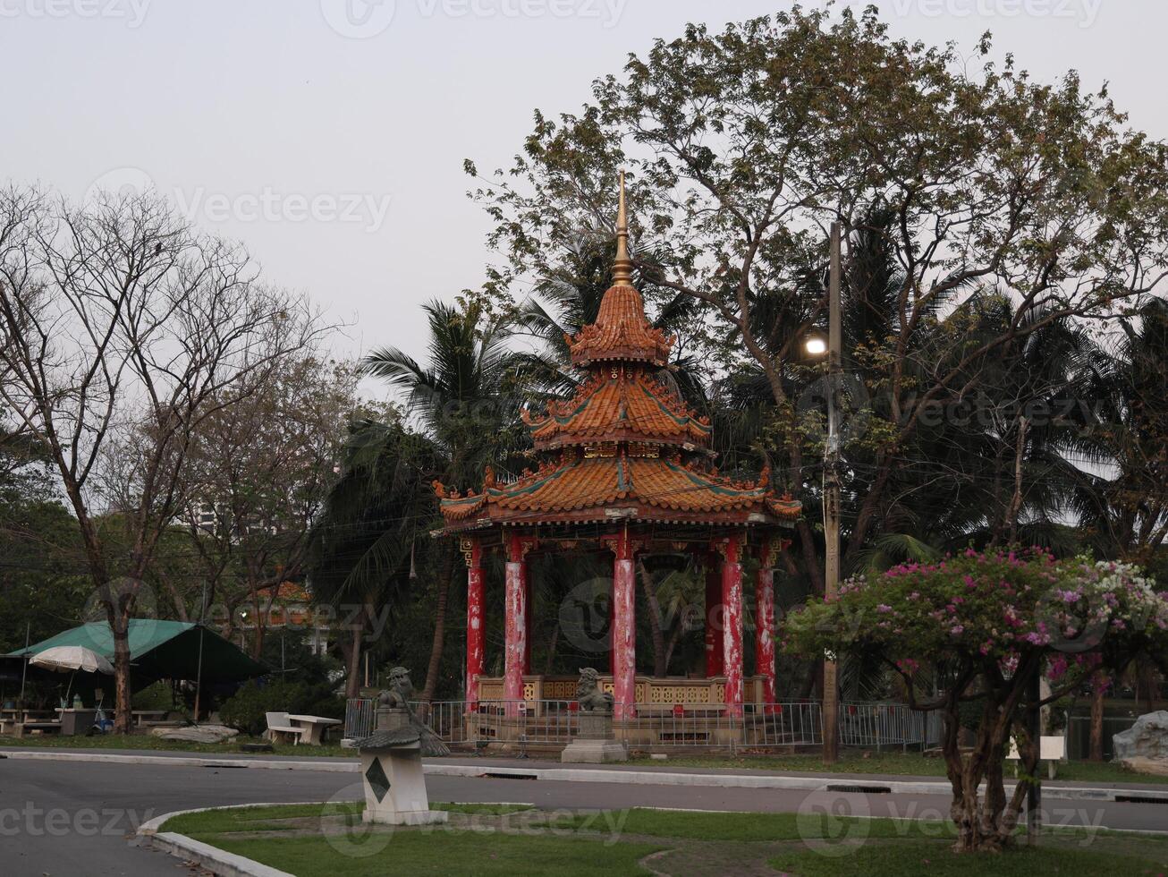 The Elegant Golden Pavilion is surrounded by lush tropical trees, creating a stunning view photo