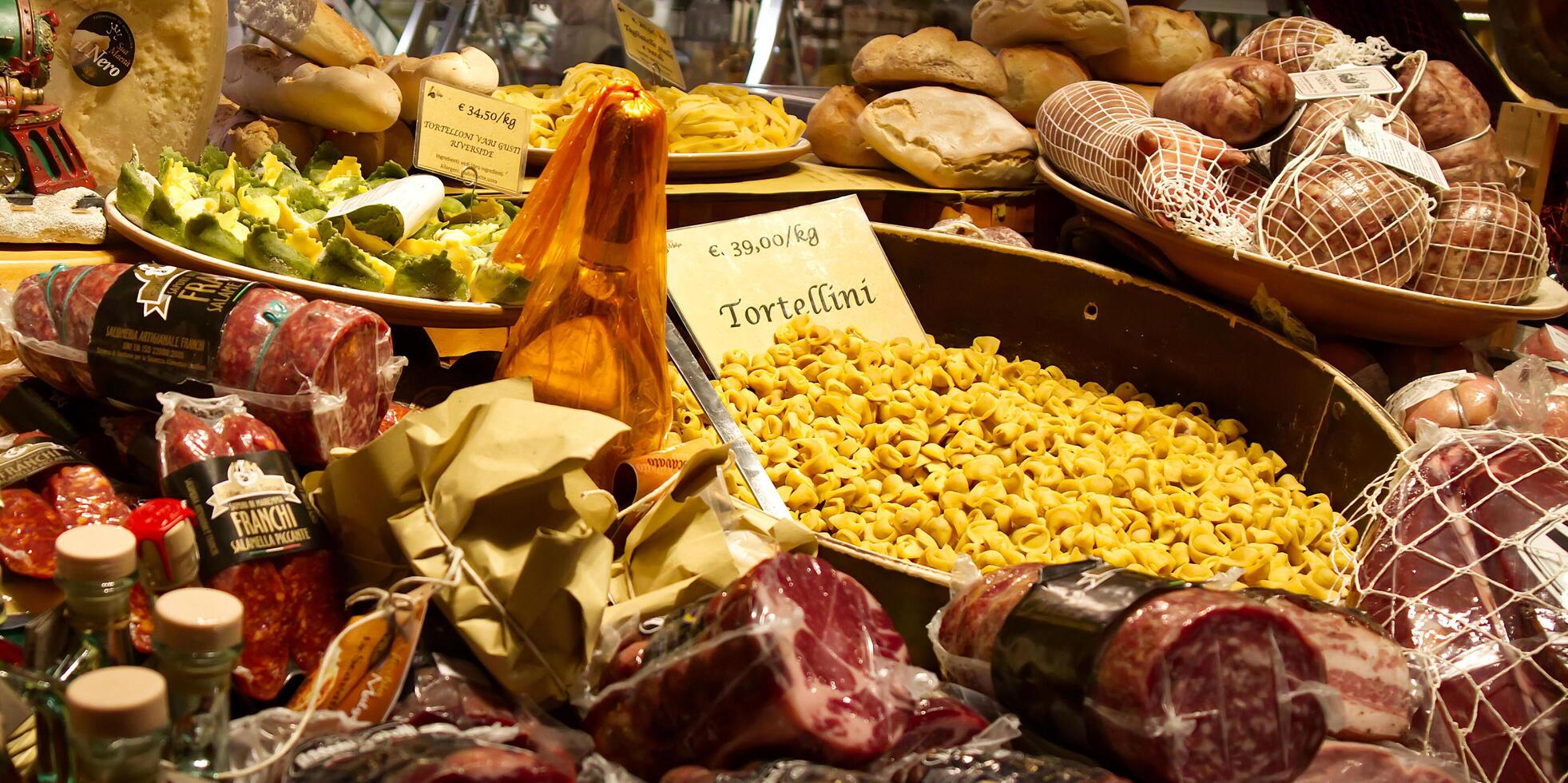 Bologna Italy December 27, 2024 A display of fresh Italian food, showcasing various types of cured meats, pasta tortellini, and breads. photo