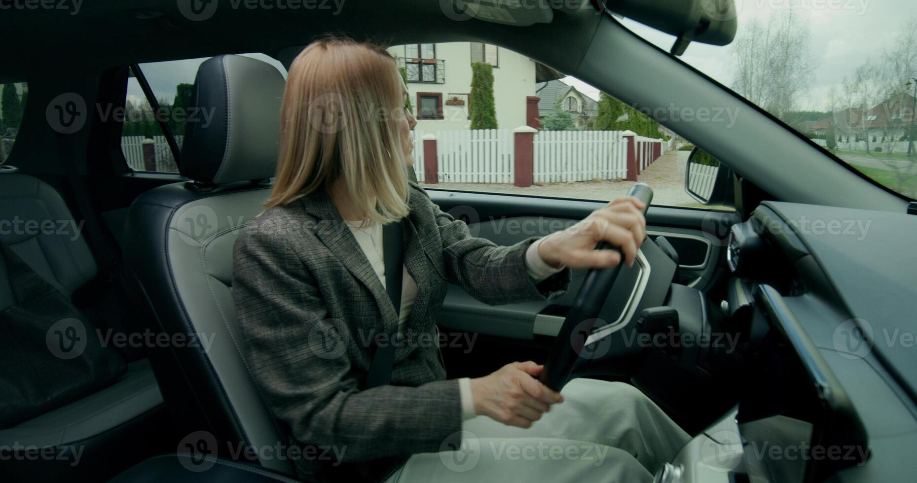 A woman driving a car with her hands on the steering wheel photo