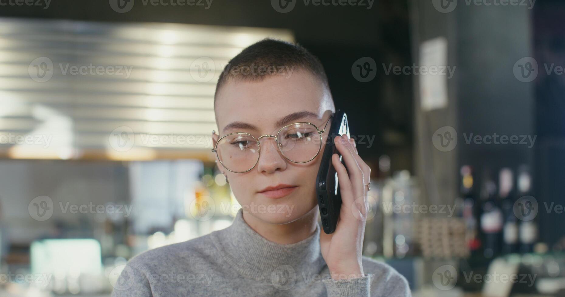 A woman with glasses talking on a cell phone photo