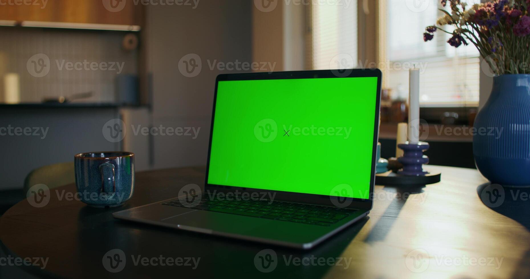 A laptop with green screen on a table photo