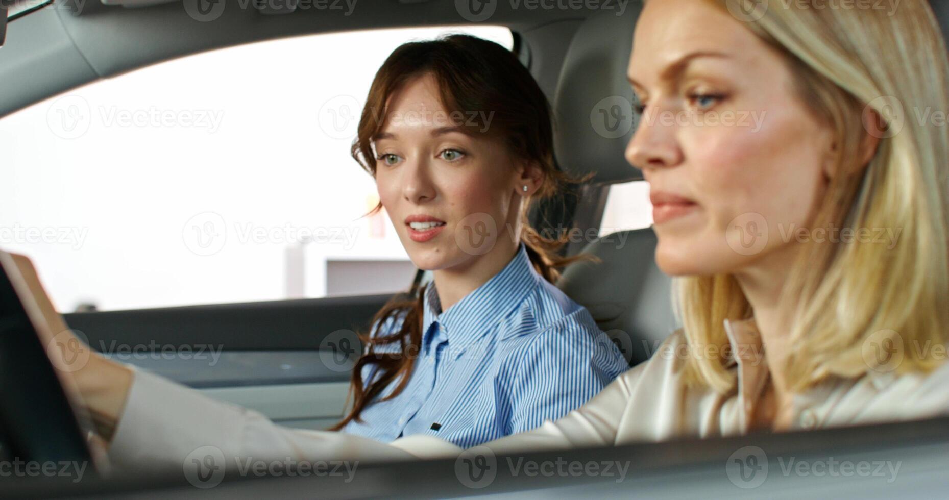 Two women in a car looking at the camera photo