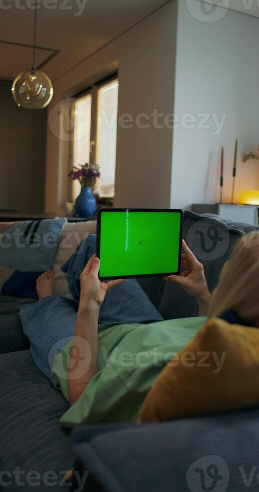 A woman is using a tablet with a green screen photo