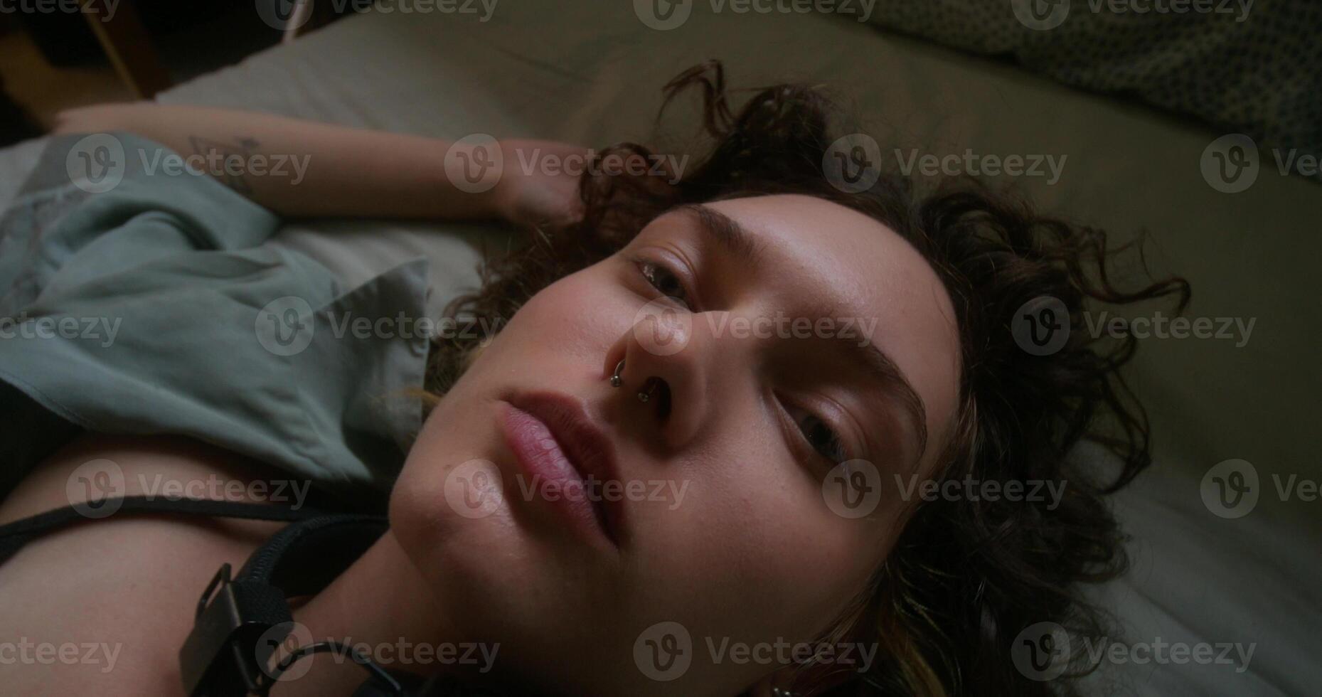 A woman laying on a bed with her eyes closed photo
