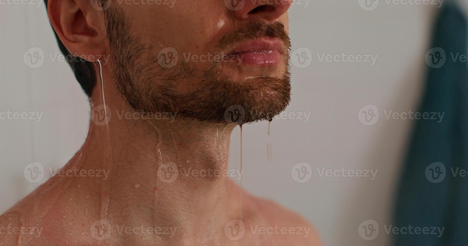 A man with wet hair and beard standing in the shower photo