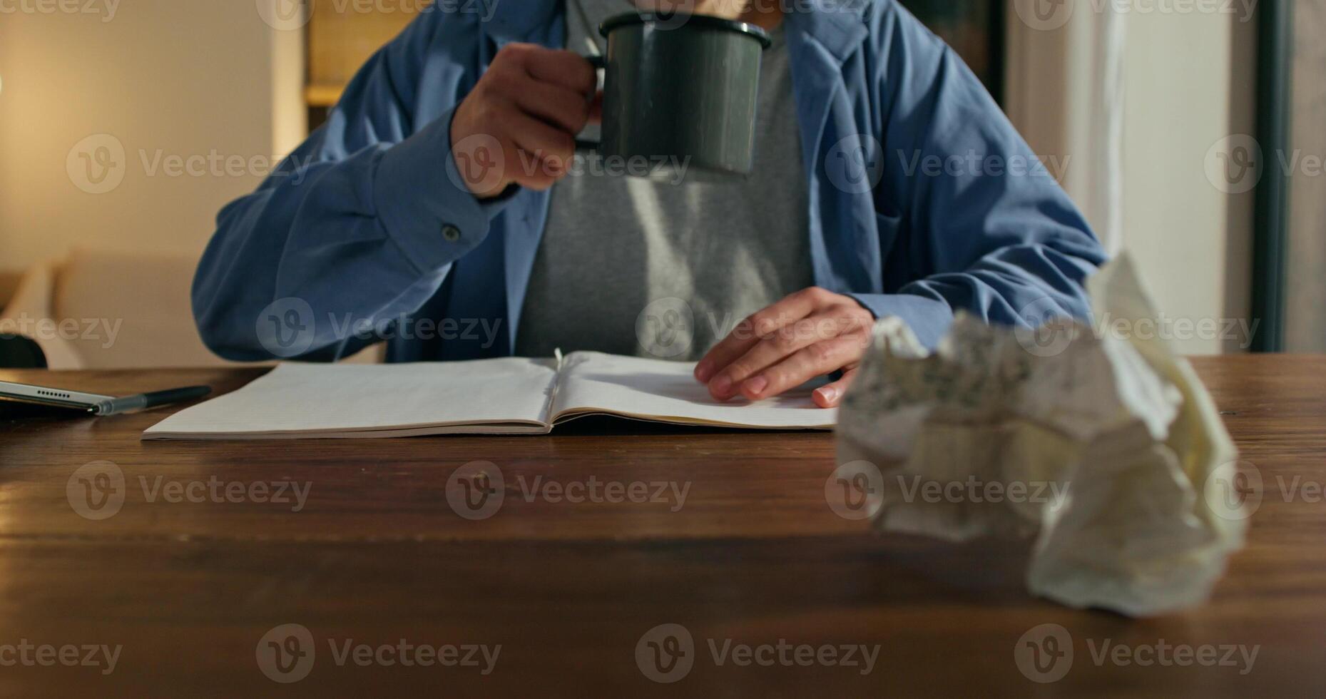 A man is sitting at a table with a cup of coffee photo