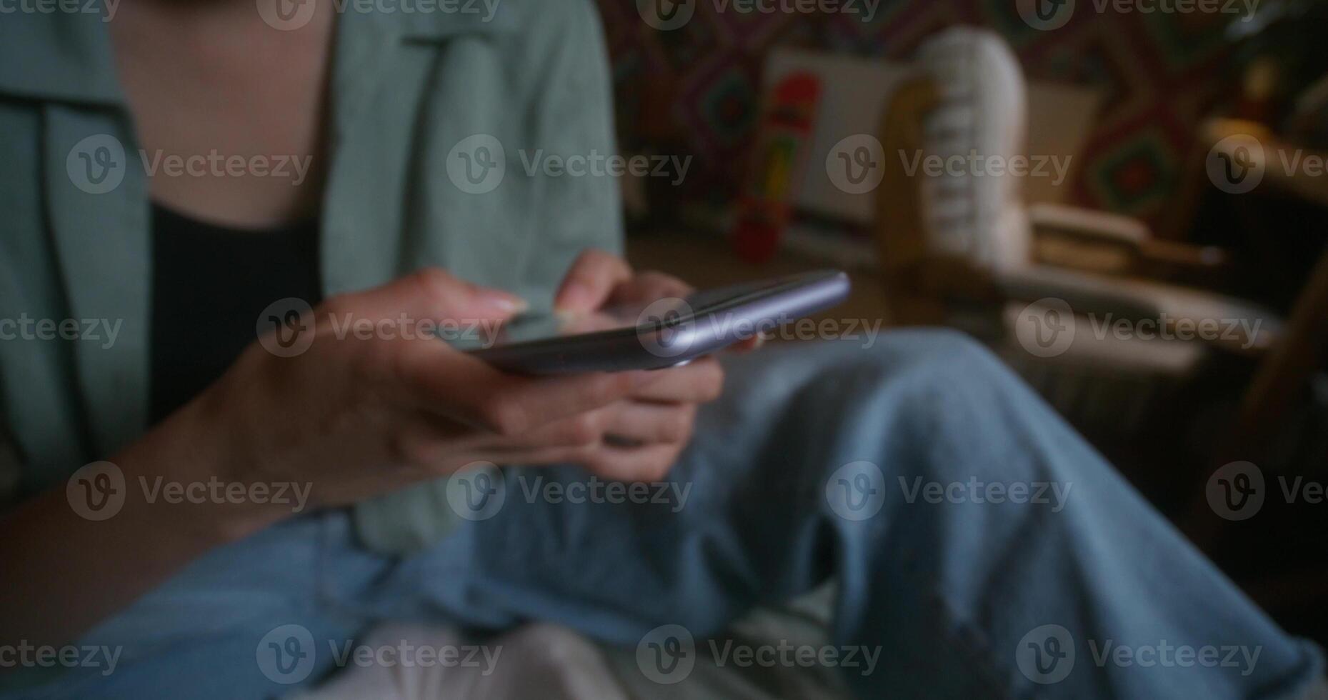 A person sitting on a bed holding a cell phone photo